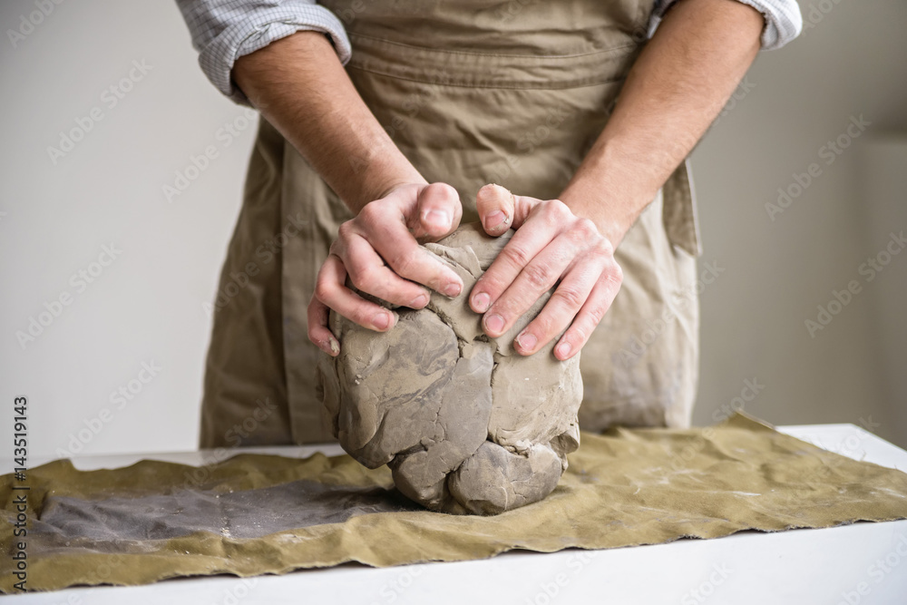 Man crumples piece of white clay for sculpting Stock Photo