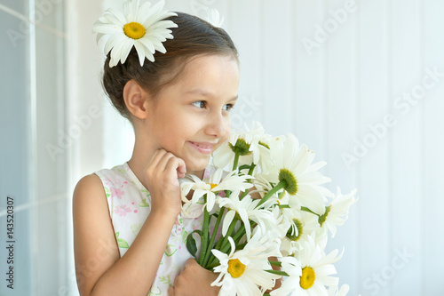 Little girl with dasies flowers photo