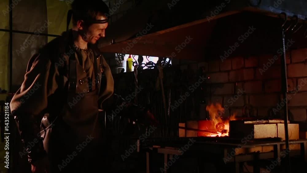 The blacksmith forging the molten metal on the anvil in smithy. close up The blacksmith forging the molten metal on the anvil in smithy. close up