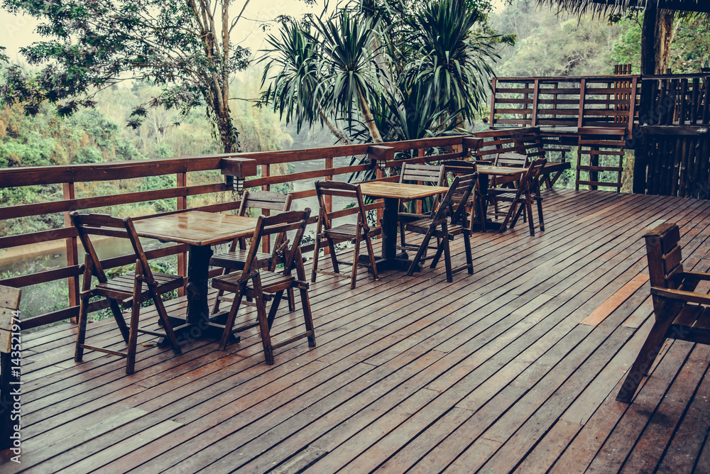 Wooden table and chair in resort and garden, dining set at wooden terrace in restaurant. vintage tone.
