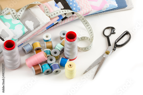 cotton fabric, tailor measurement tape and spools of cotton thread