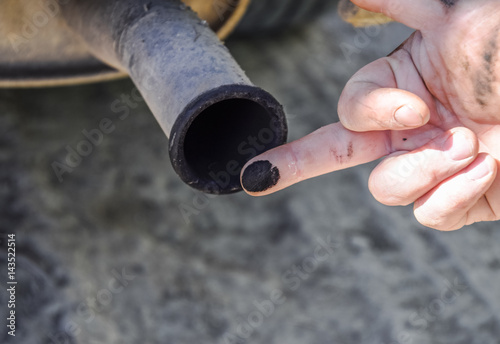 Soot from the exhaust pipe on the finger. Examination of the car's exhaust system by the automaker photo