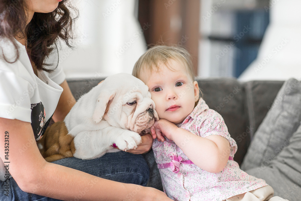 Sweet girl hugs and kisses the puppy on the arms of my mother