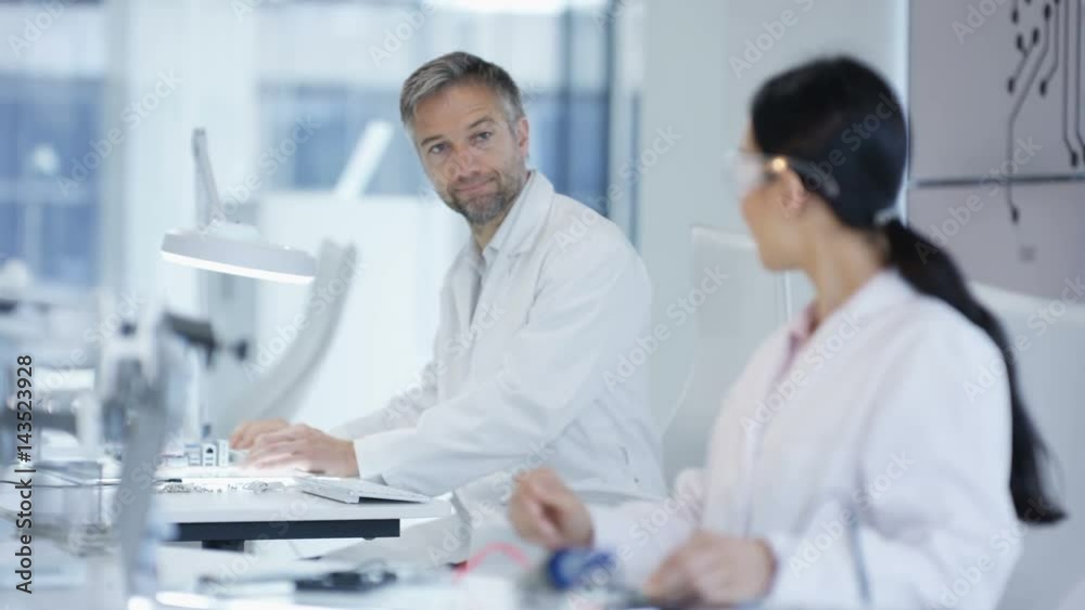 Electronics engineers working in lab building & testing electronic devices Electronics engineers working in lab building & testing electronic devices