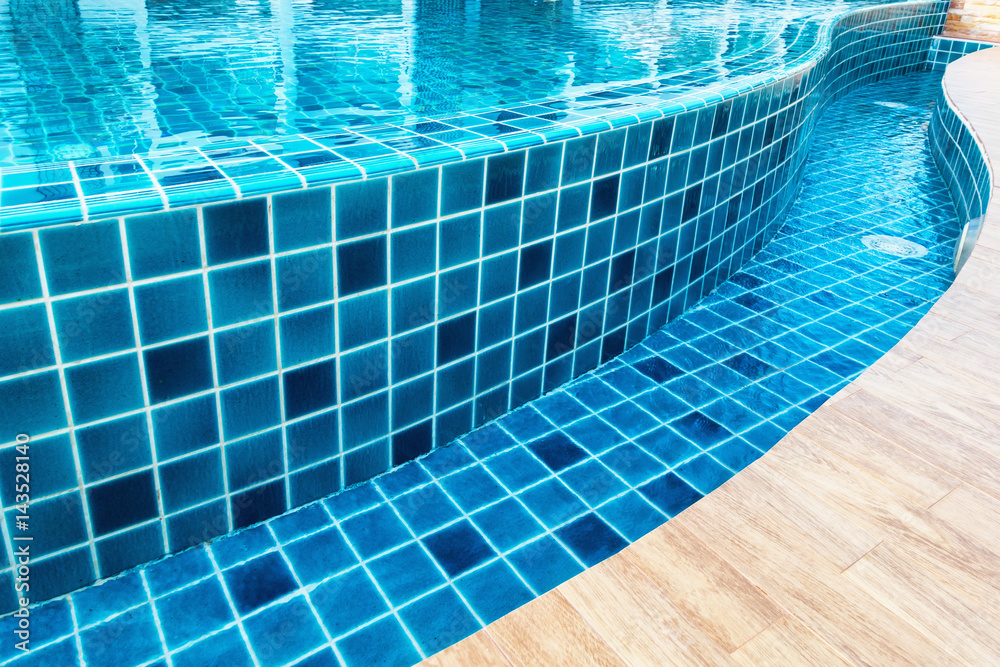 Ceramic tile of swimming pool with water reflection.,