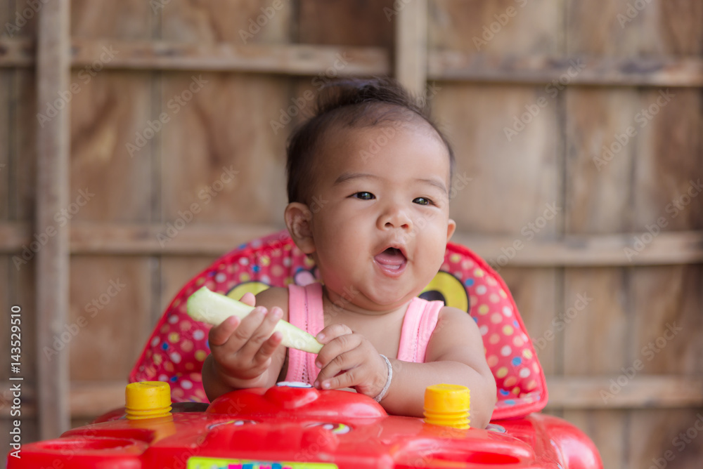 Cute asian baby toddler girl sitting on red stroller. Cute asian baby toddler girl sitting on red stroller.