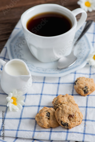 Homemade oatmeal and raisin cookies with a cup of coffee.