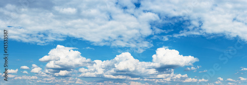 Blue sky with fluffy clouds. The feeling of space. Background. Horizontal frame view.