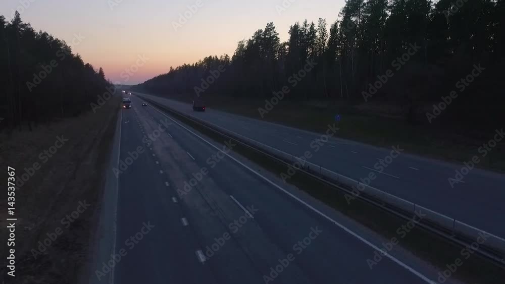 Aerial view, highway near the forest, cars and trucks drive on the road, traffic on the highway. View from a height on a sunset. 50fps.
Aerial view, highway near the forest, cars and trucks drive on the road, traffic on the highway. View from a height on a sunset. 50fps.