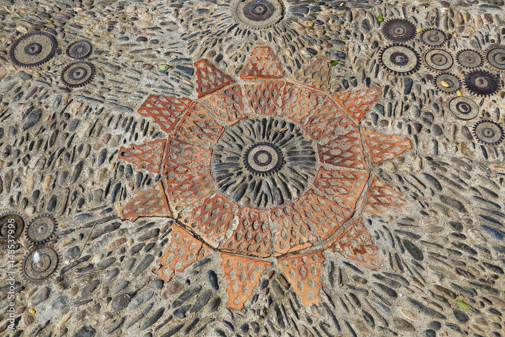Patterned floor with pattern from pebbles bricks and gears