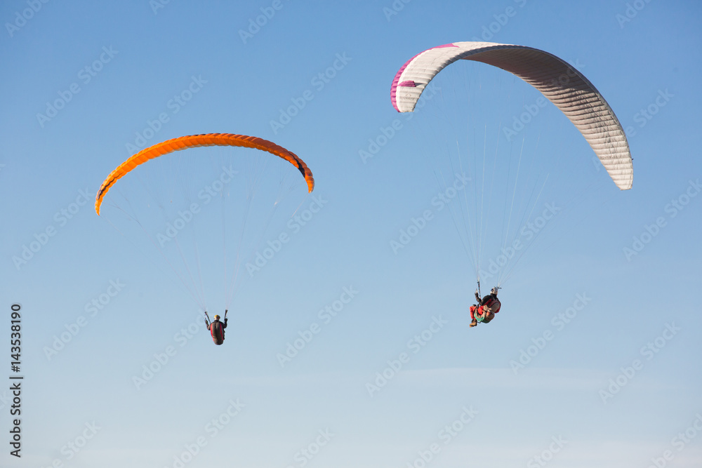 dos volando suspendidos en el cielo con su parapente dos volando suspendidos en el cielo con su parapente