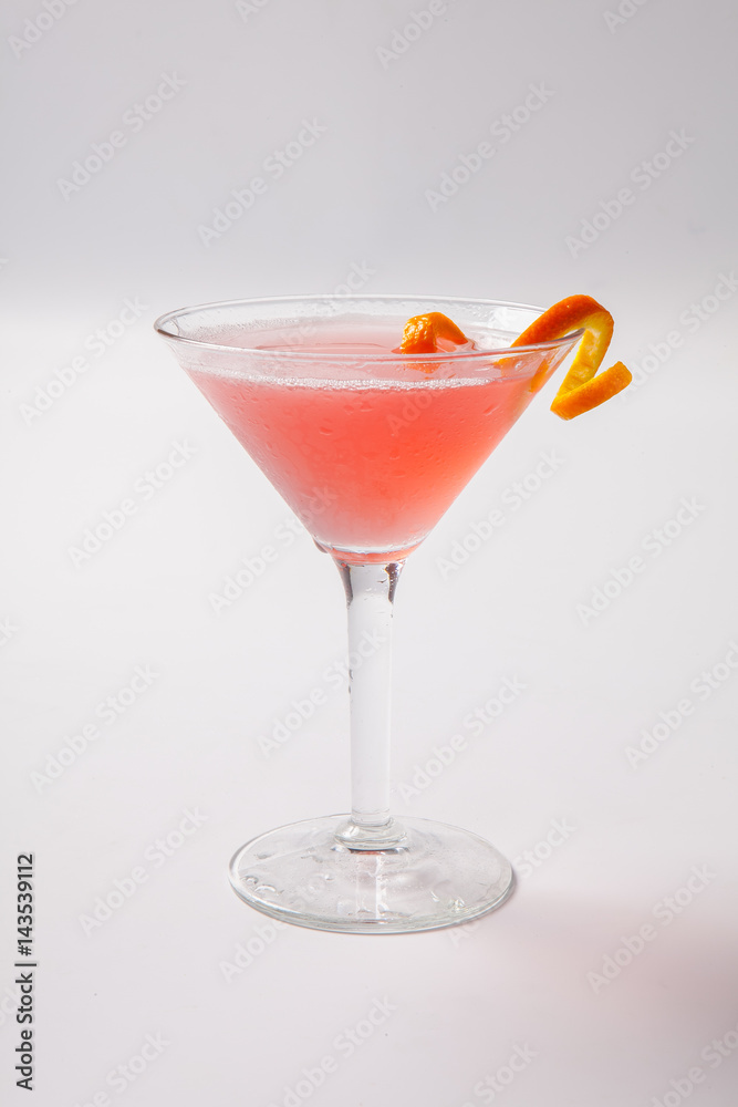 Red cocktail with orange garnish on a whithe background Red cocktail with orange garnish on a whithe background