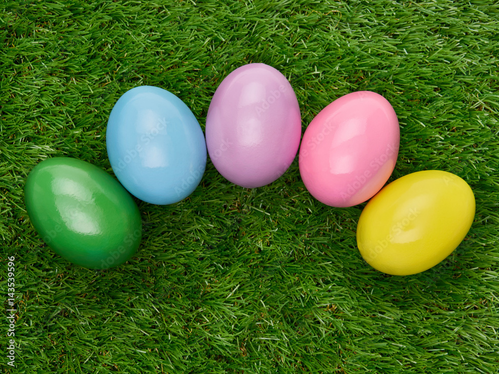 Colourful painted decorated Easter Eggs on a green grass  background.