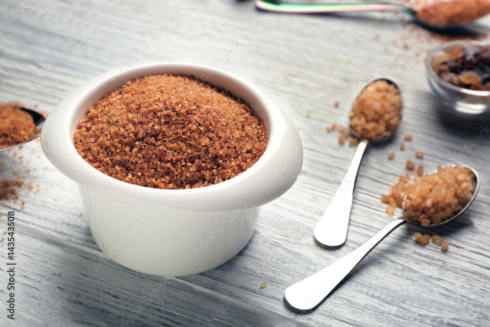 Bowl and spoons with brown sugar on wooden table Bowl and spoons with brown sugar on wooden table
