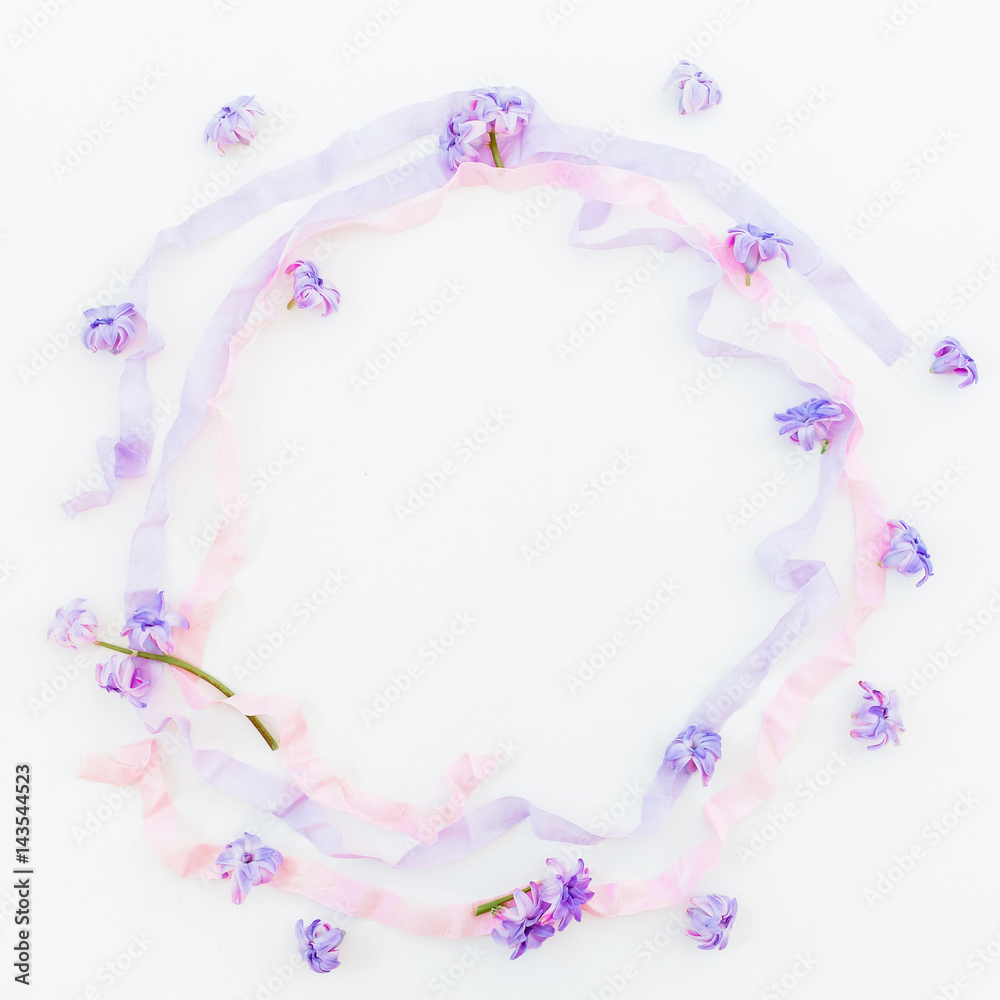 Frame of pink hyacinth, petals and purple tapes on white background. Flat lay, top view.