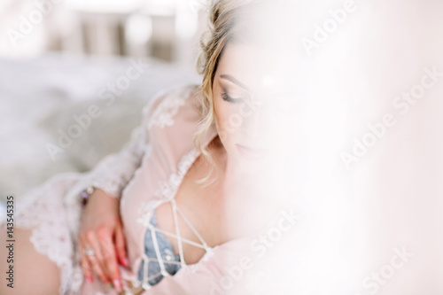 the bride in a Bathrobe to the bedroom window in the morning