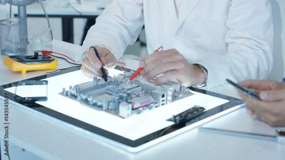 Electronics engineers working in lab building & testing electronic devices Electronics engineers working in lab building & testing electronic devices