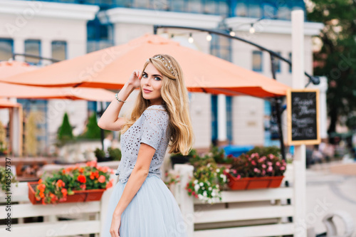 Pretty girl with long blonde hair smiling to camera on terrace background © Look!