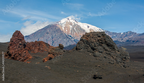 The old lava flow from a crater on the slopes of volcanoes Tolbachik (on background) - Kamchatka, Russia photo