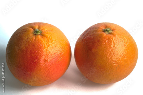 Closeup of two red grapefruits on a white background