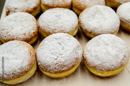 Donuts sprinkled with powdered sugar.