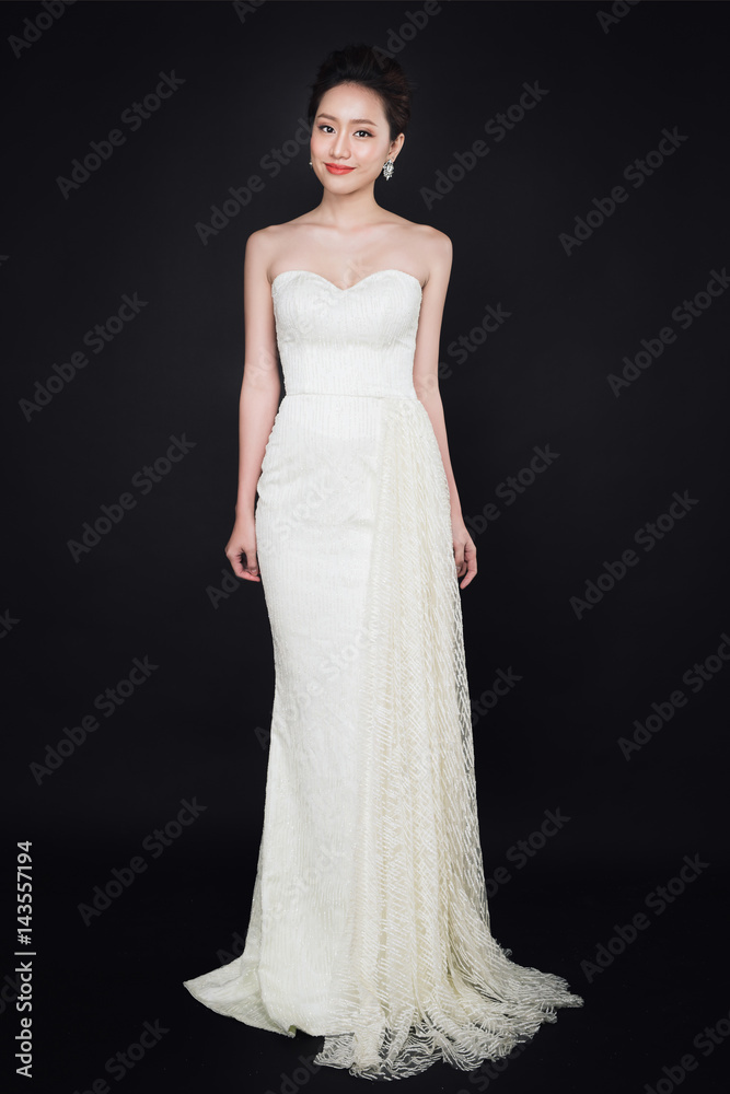 Full length of smart asian lady wearing white dress