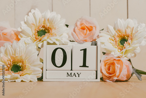 May 1st. Image of may 1 white block calendar on white background with flowers. Spring day, empty space for text. International Workers' Day