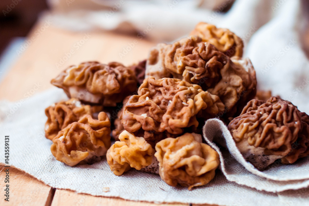 Mushrooms morel on a linen tablecloth and wooden background. Mushrooms morel on a linen tablecloth and wooden background.