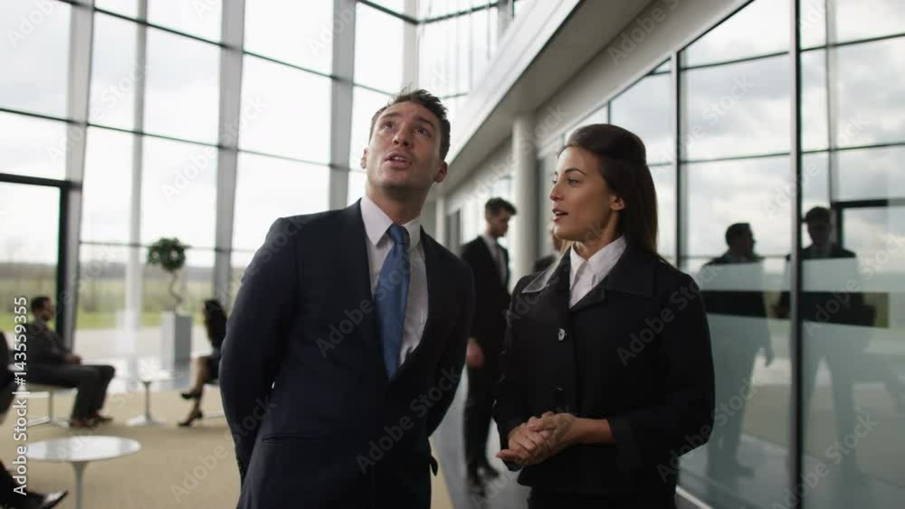 Business people talking as they walk through lobby of office building Business people talking as they walk through lobby of office building