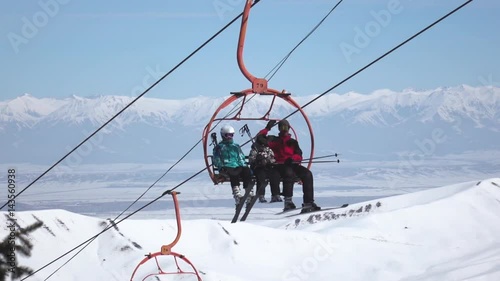 Ski lift chairs on winter day. old chair ski lift in ski resort.people ride the ski chair lift up the mountain.Ski chair lift with skiers