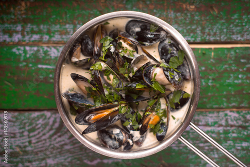Mussels in Roquefort sauce  on the old wooden painted background top view © deniskarpenkov