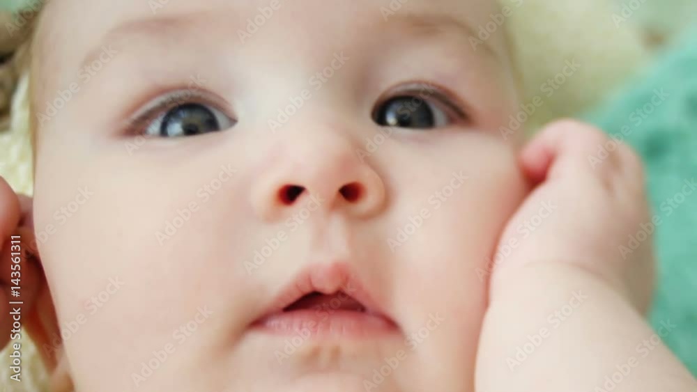 baby is lying in bed on the back in yellow knit clothes baby is lying in bed on the back in yellow knit clothes