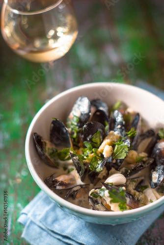 Mussels in Roquefort sauce on the blurred background vertical