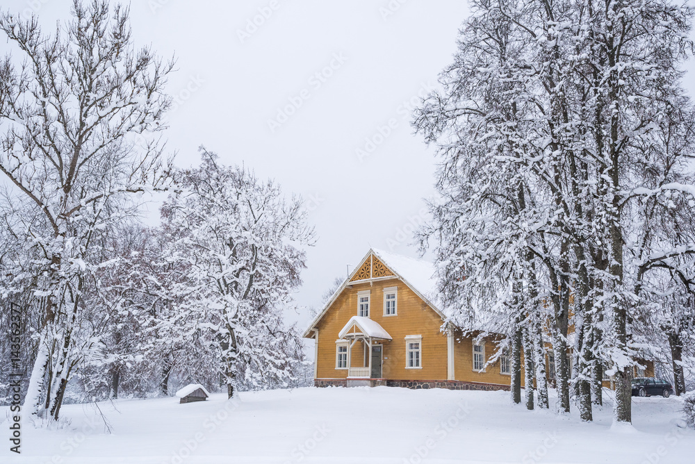 Naklejka premium Old wooden house in Turaida castle park. winter. Sigulda, Latvia 
