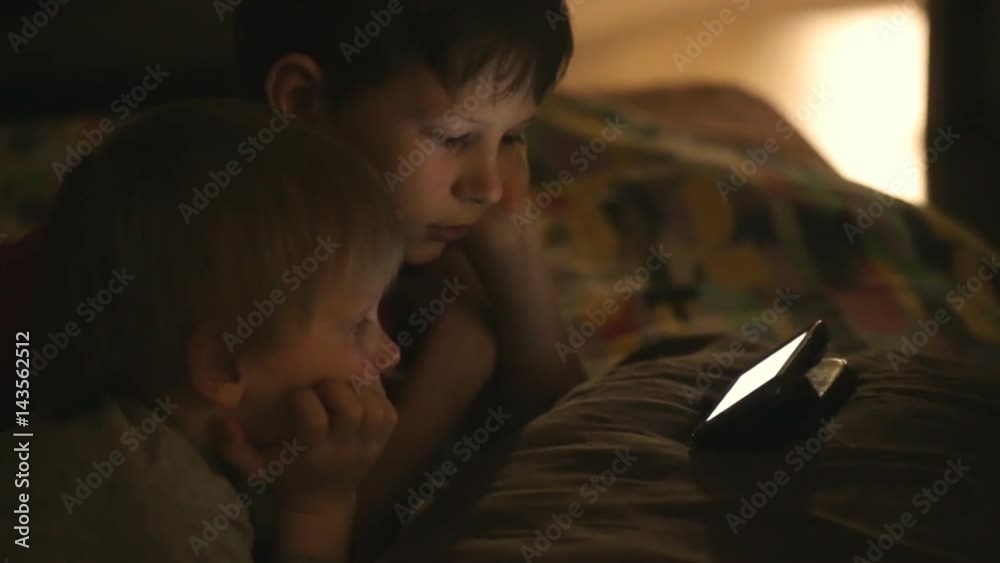 Children watch cartoons in a dark room Children watch cartoons in a dark room
