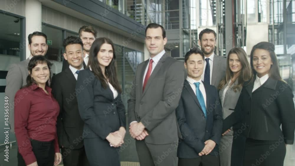 Portrait smiling diverse business group in large modern office building Portrait smiling diverse business group in large modern office building