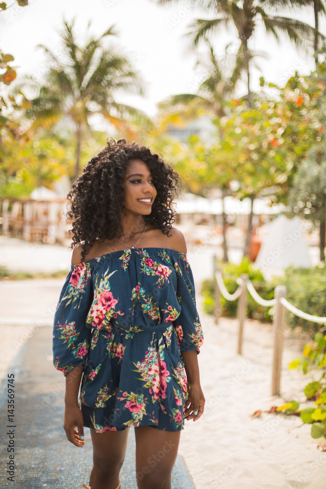 Naklejka premium Fashion woman walking on beach with a summer dress