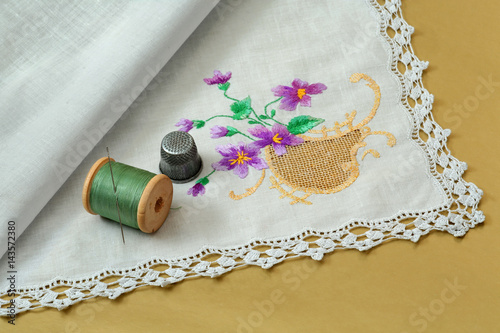 Thread with a needle, a thimble and a handkerchief