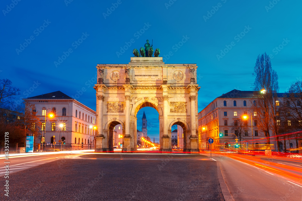 The Siegestor or Victory Gate, triumphal arch crowned with a statue of Bavaria with a lion-quadriga, at night in Munich, Germany