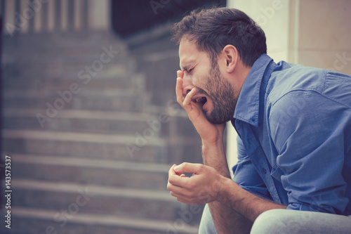 Canvas Print sorrowful crying man sitting on steps outdoors