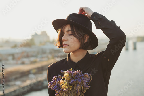 Adorable girl portrait with flowers. Urban port city background photo