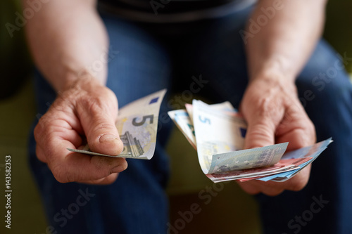 Close up hands of old woman counting money