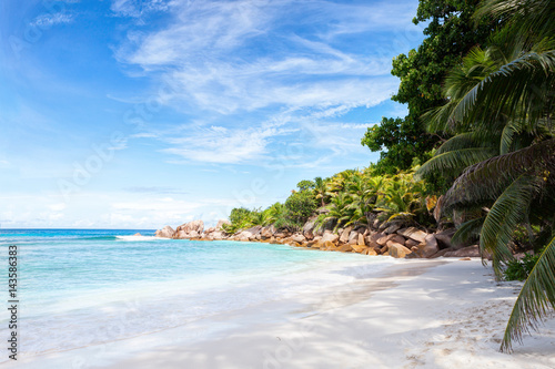 Beautiful tropical sand beach with granite rocks and coconut palm trees. La Digue, Seychelles.