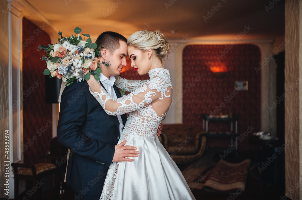 Loving bride and groom tenderly embrace.