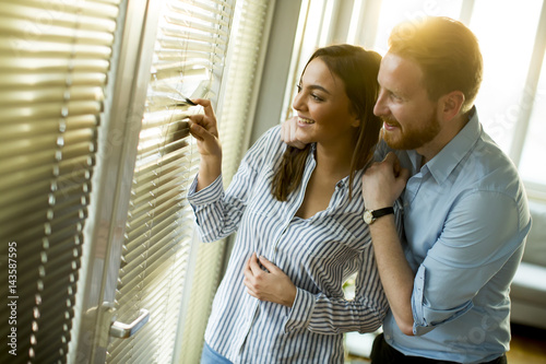 Attractive couple looking trough the room window