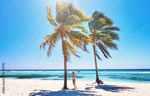Young woman on beach cheerful joyful  coconut  palm trees. Beach  Caribbean Sea  Cuba