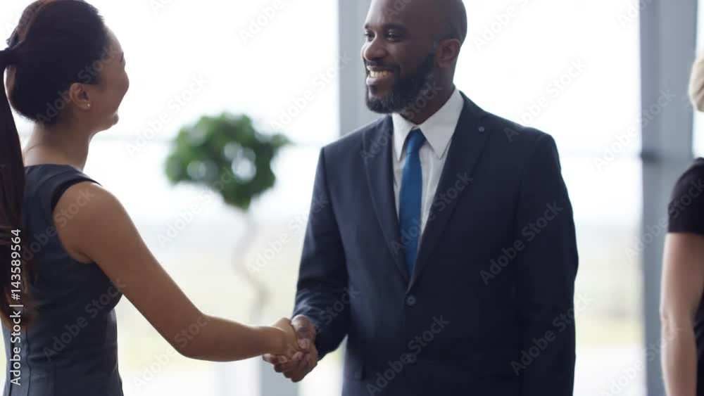  Portrait smiling businessman shaking hands with clients at end of meeting