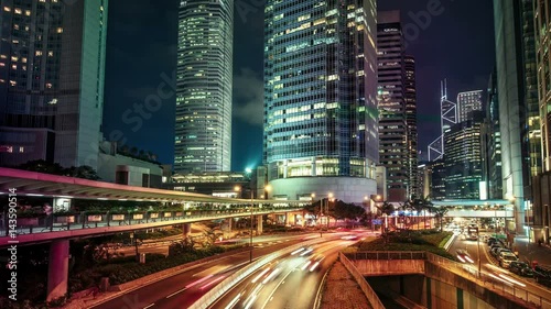 Roads with car trails in Hong Kong financial district at night. Scenic view of big illuminated city with skyscrapers and fast moving traffic. Colourful 4K Time lapse. 