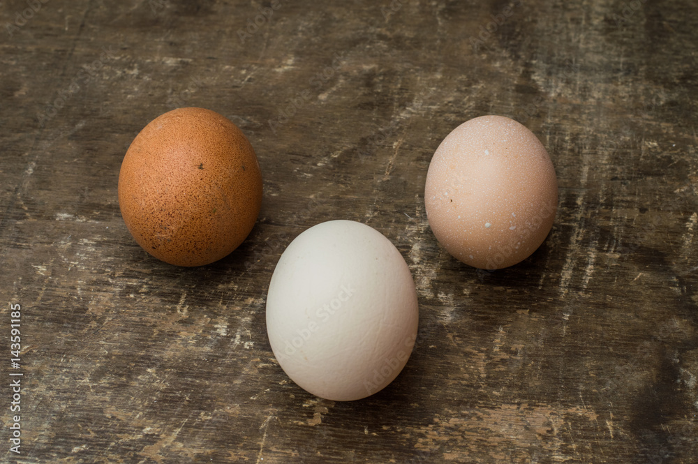 Three fresh chicken eggs on an old wooden background Three fresh chicken eggs on an old wooden background