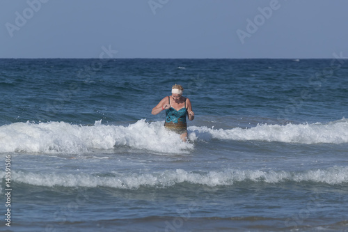 Middle-aged woman comes out of the sea